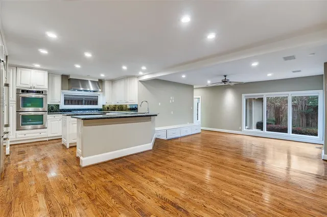 a view of kitchen with kitchen island wooden floor appliances and center island