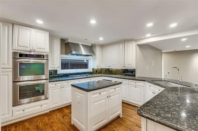 a kitchen with granite countertop a stove sink and microwave