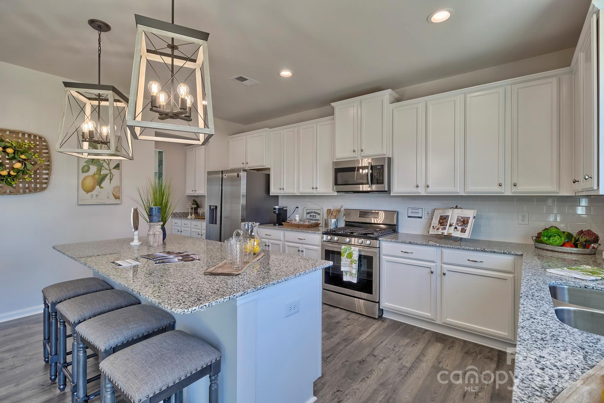 6504 Alanbrook Road, Unit 63 Charlotte, NC 28215 - Photo 13 of 25 a kitchen with kitchen island granite countertop a sink cabinets and stainless steel appliances