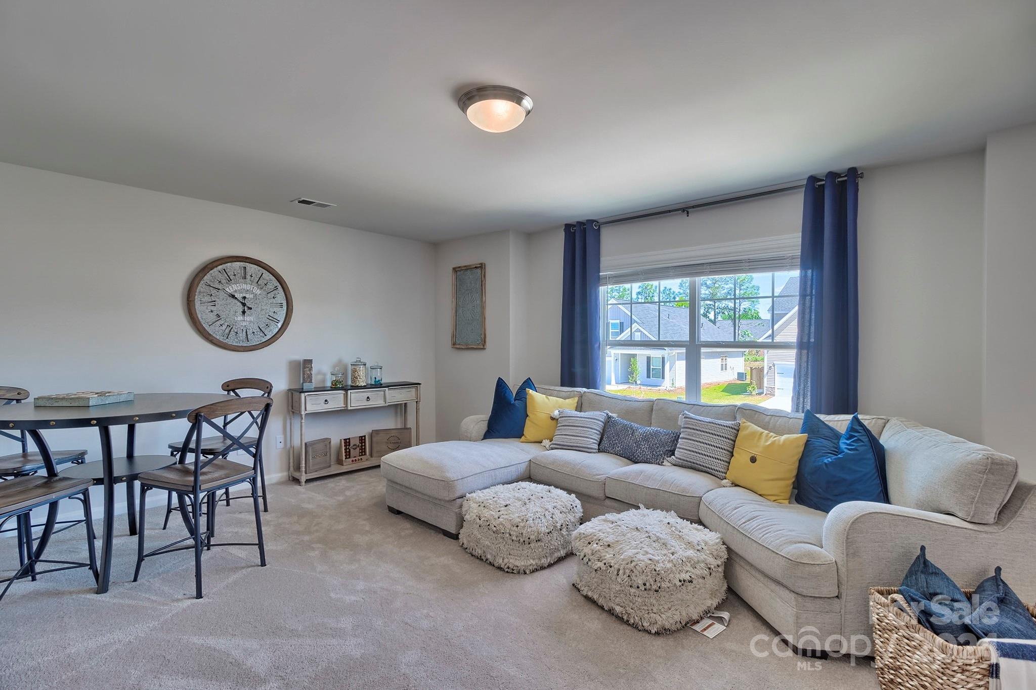 6504 Alanbrook Road, Unit 63 Charlotte, NC 28215 - Photo 20 of 25 a living room with furniture a large window and a clock