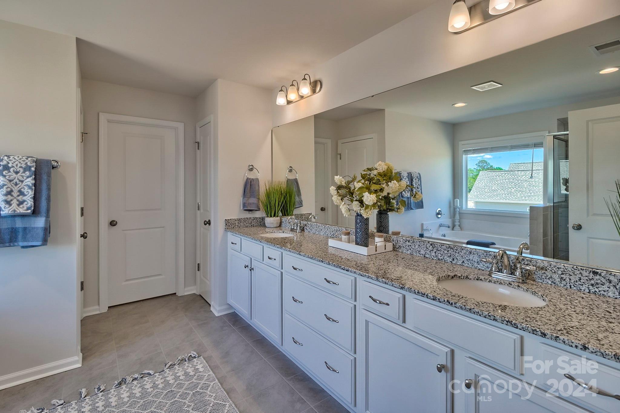 6504 Alanbrook Road, Unit 63 Charlotte, NC 28215 - Photo 25 of 25 a bathroom with a double vanity sink and a mirror