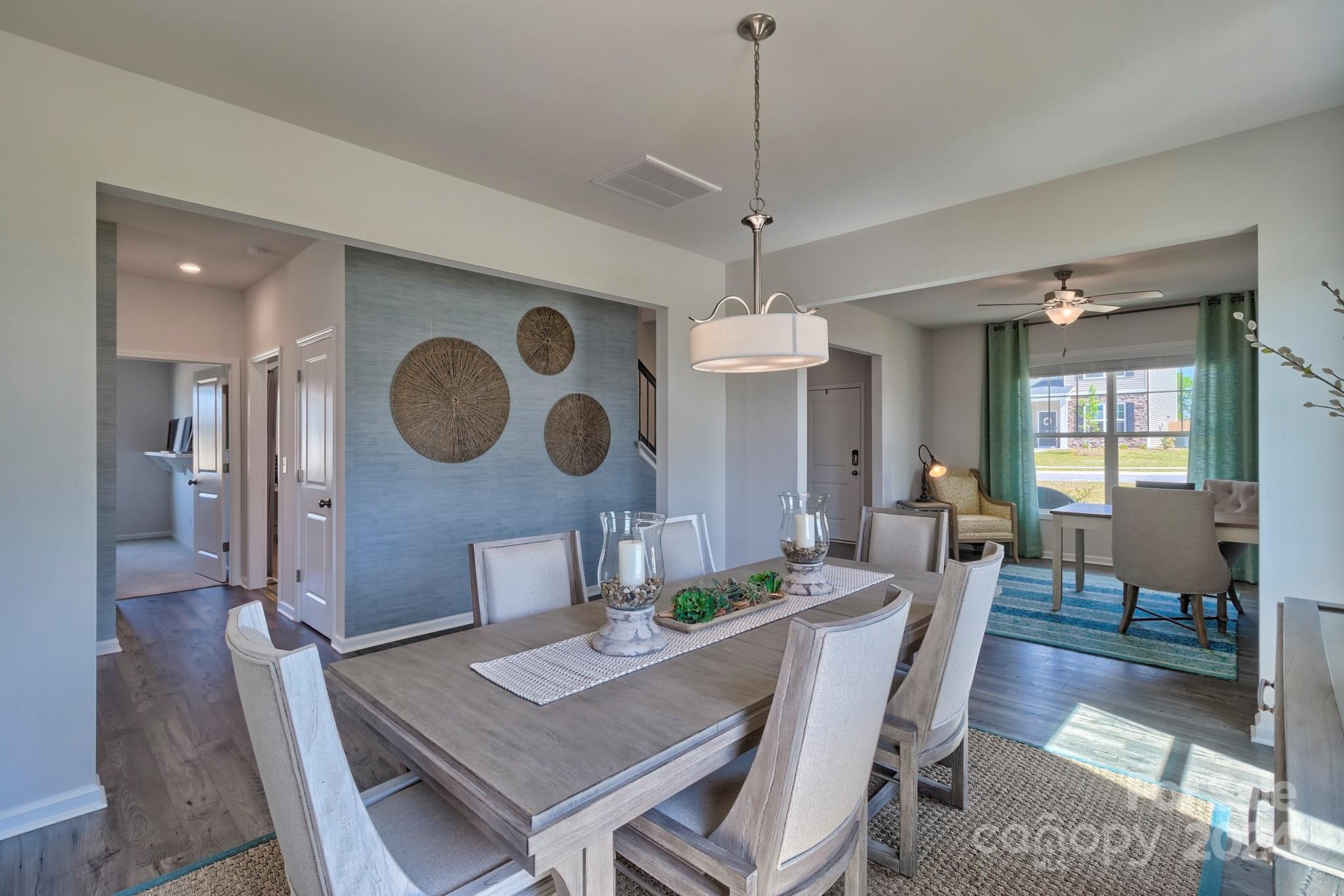 6504 Alanbrook Road, Unit 63 Charlotte, NC 28215 - Photo 7 of 25 a view of a dining room with furniture a chandelier and wooden floor