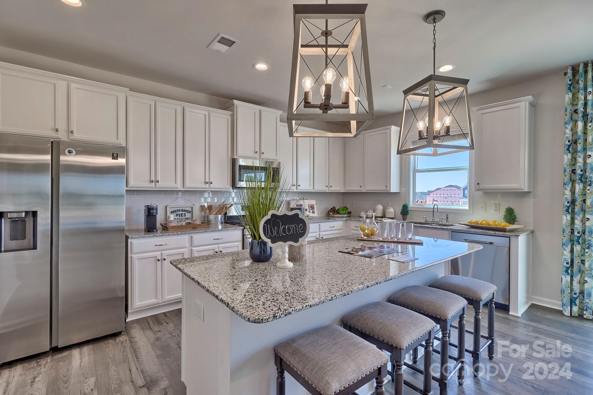 6504 Alanbrook Road, Unit 63 Charlotte, NC 28215 - Photo 10 of 25 a kitchen with kitchen island granite countertop a sink cabinets and stainless steel appliances