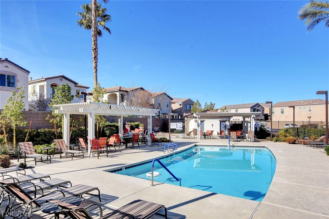 48 Jasmine Point Street Henderson, NV 89074 - Photo 7 of 62 Lounge in the sun by a refreshing pool, complete with a covered pergola for shade.