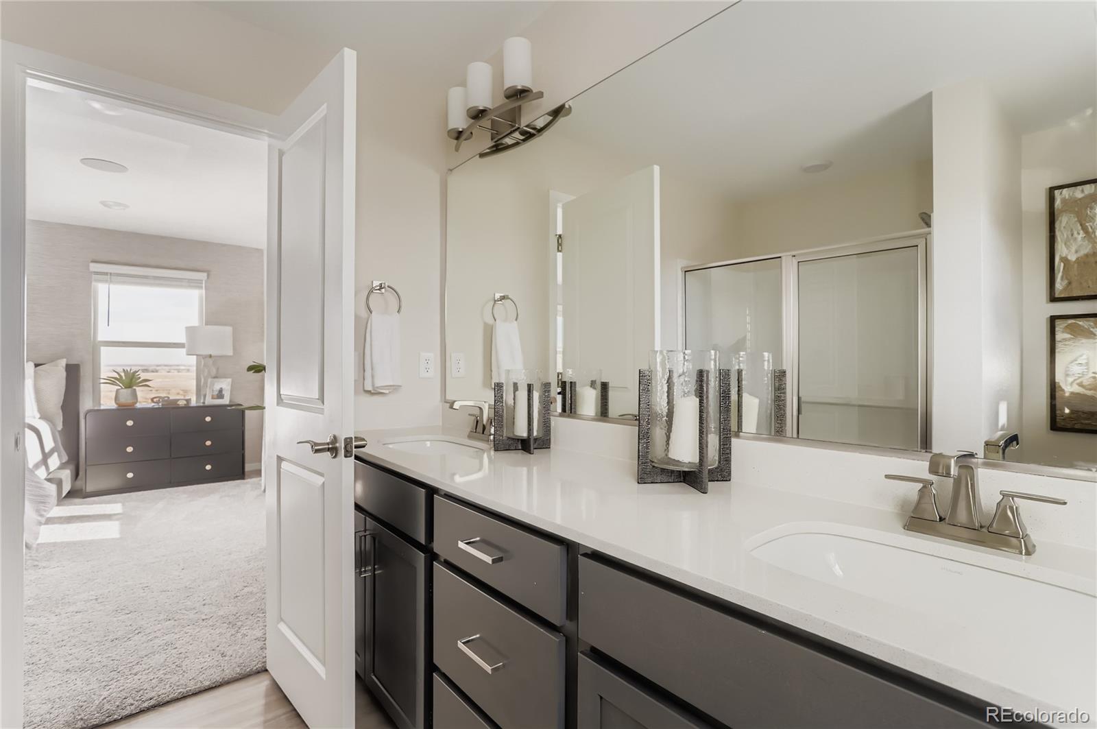 13322 Ladybug Lane Firestone, CO 80504 - Photo 17 of 22 a bathroom with double vanity sinks a vanity a lamp and a mirror