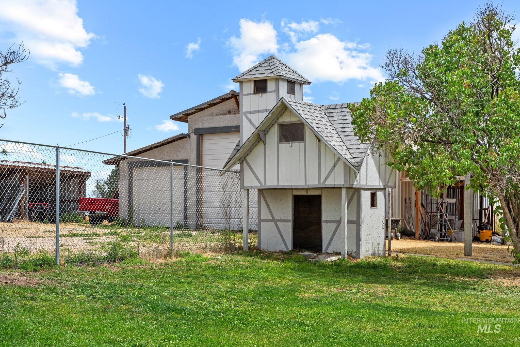 18338 Pride Lane Caldwell, ID 83607 - Photo 47 of 50 Manicured lawn with a decorative Tudor-style shed featuring a turret