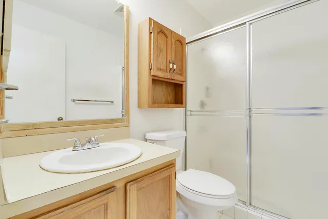 a bathroom with a sink toilet vanity and shower