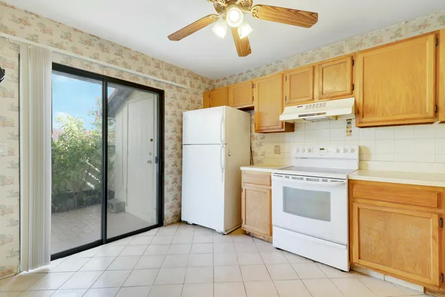 a kitchen with a refrigerator sink and cabinets
