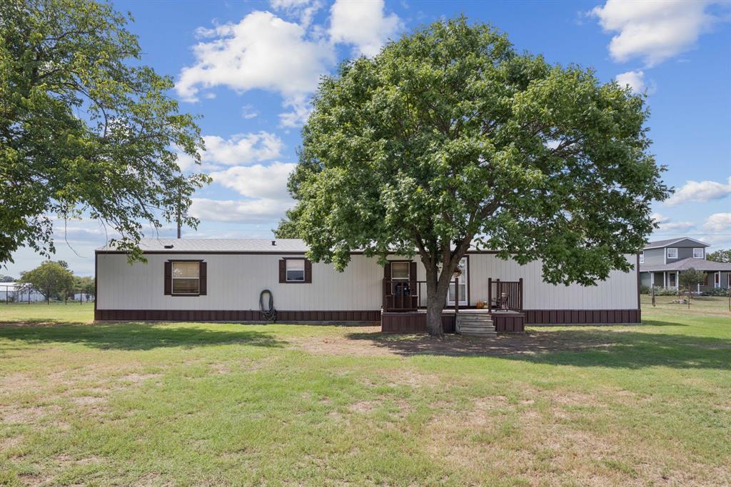 510 North Cardinal Road Azle, TX 76020 - Photo 1 of 1 Manufactured home with a front yard and a wooden deck.