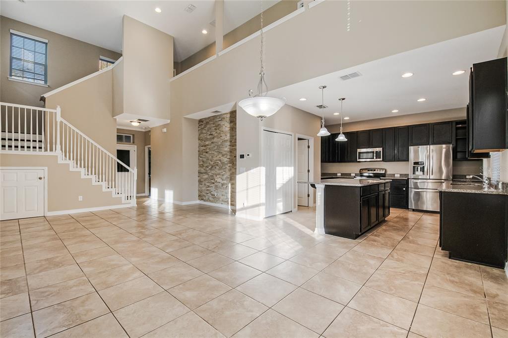 6844 Sundrop Street Harmony, FL 34773 - Photo 19 of 67 a kitchen with stainless steel appliances kitchen island granite countertop a stove a sink and a refrigerator