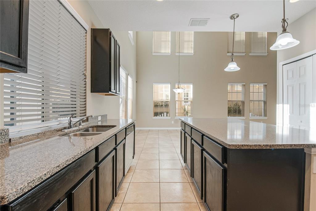 6844 Sundrop Street Harmony, FL 34773 - Photo 22 of 67 a kitchen with granite countertop a sink stove and refrigerator
