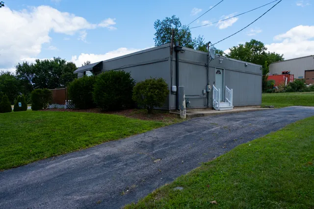 a view of a house with backyard and a tree