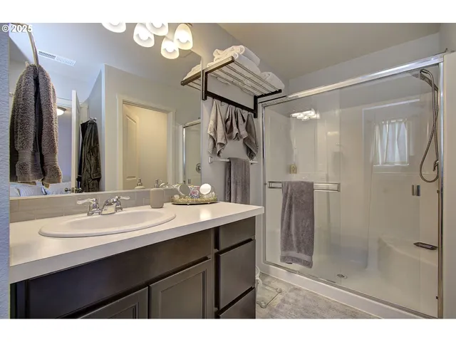 a bathroom with a sink mirror and shower