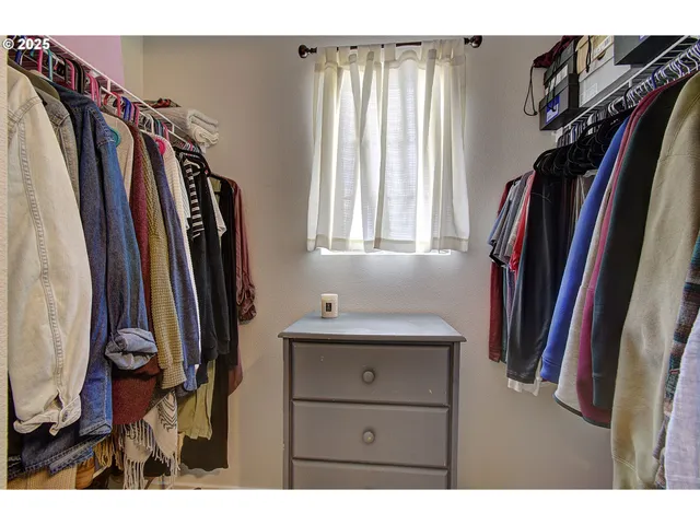 a view of walk in closet with clothes