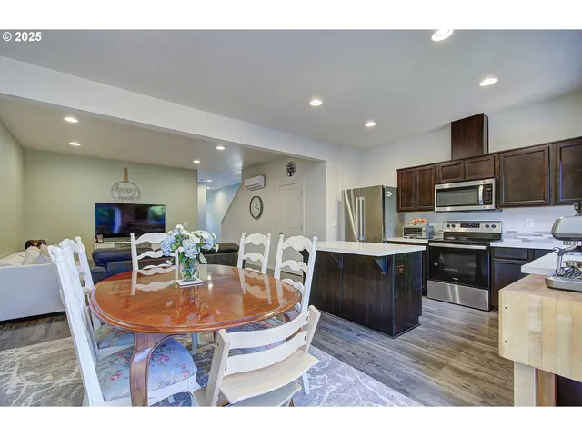 a kitchen with a table chairs microwave and cabinets