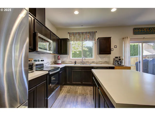 a kitchen with stainless steel appliances granite countertop a sink stove and refrigerator