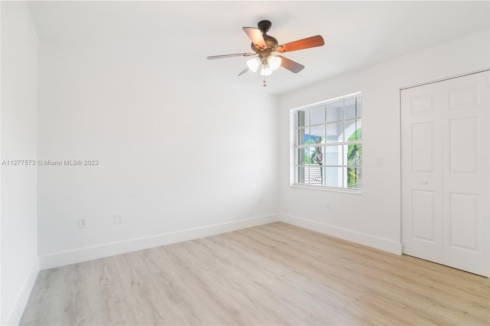 Silver Falls Miramar, FL 33027 - Photo 20 of 46 an empty room with wooden floor chandelier fan and windows