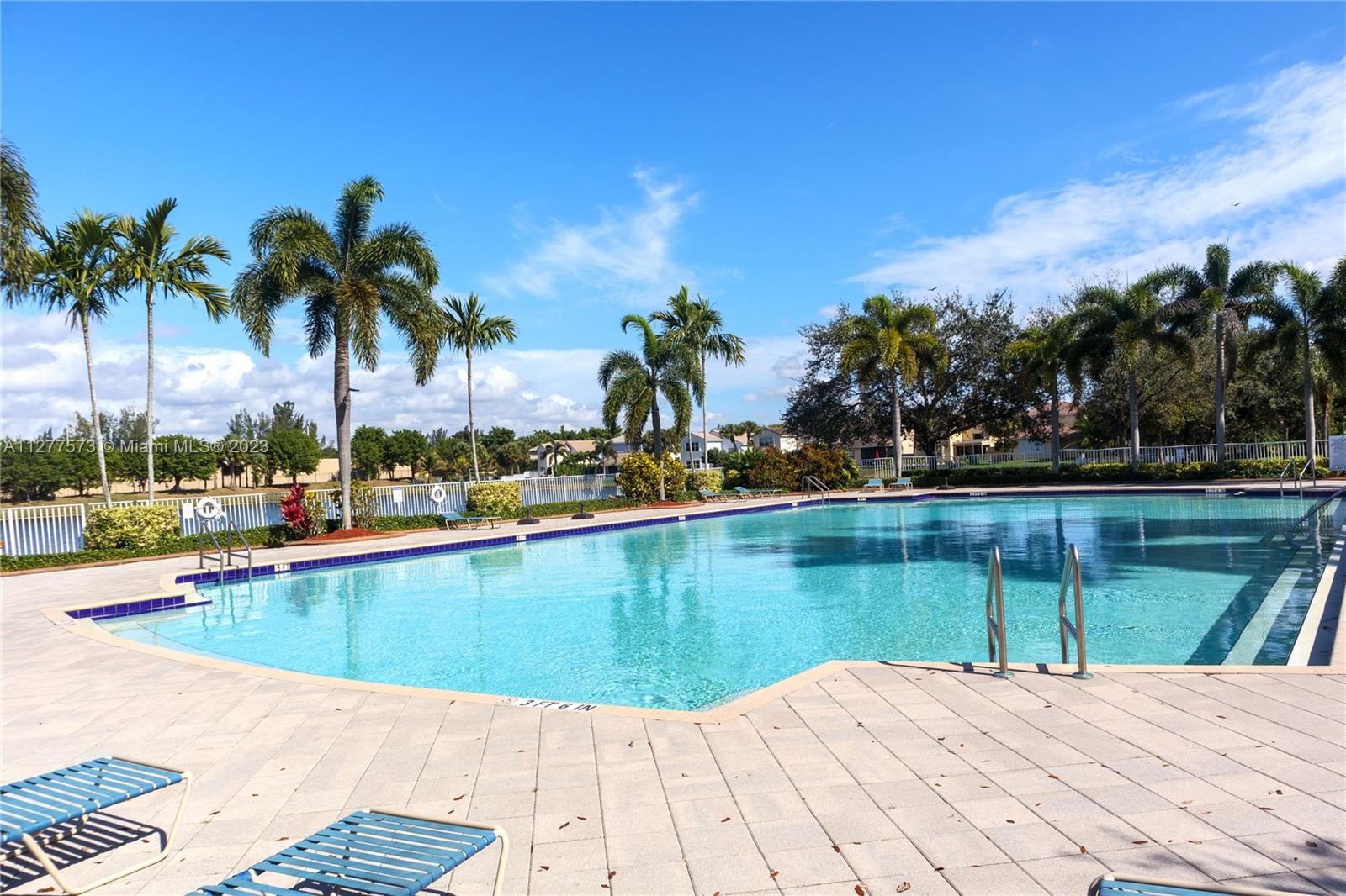 Silver Falls Miramar, FL 33027 - Photo 32 of 46 a view of a swimming pool with a lawn chairs under palm trees