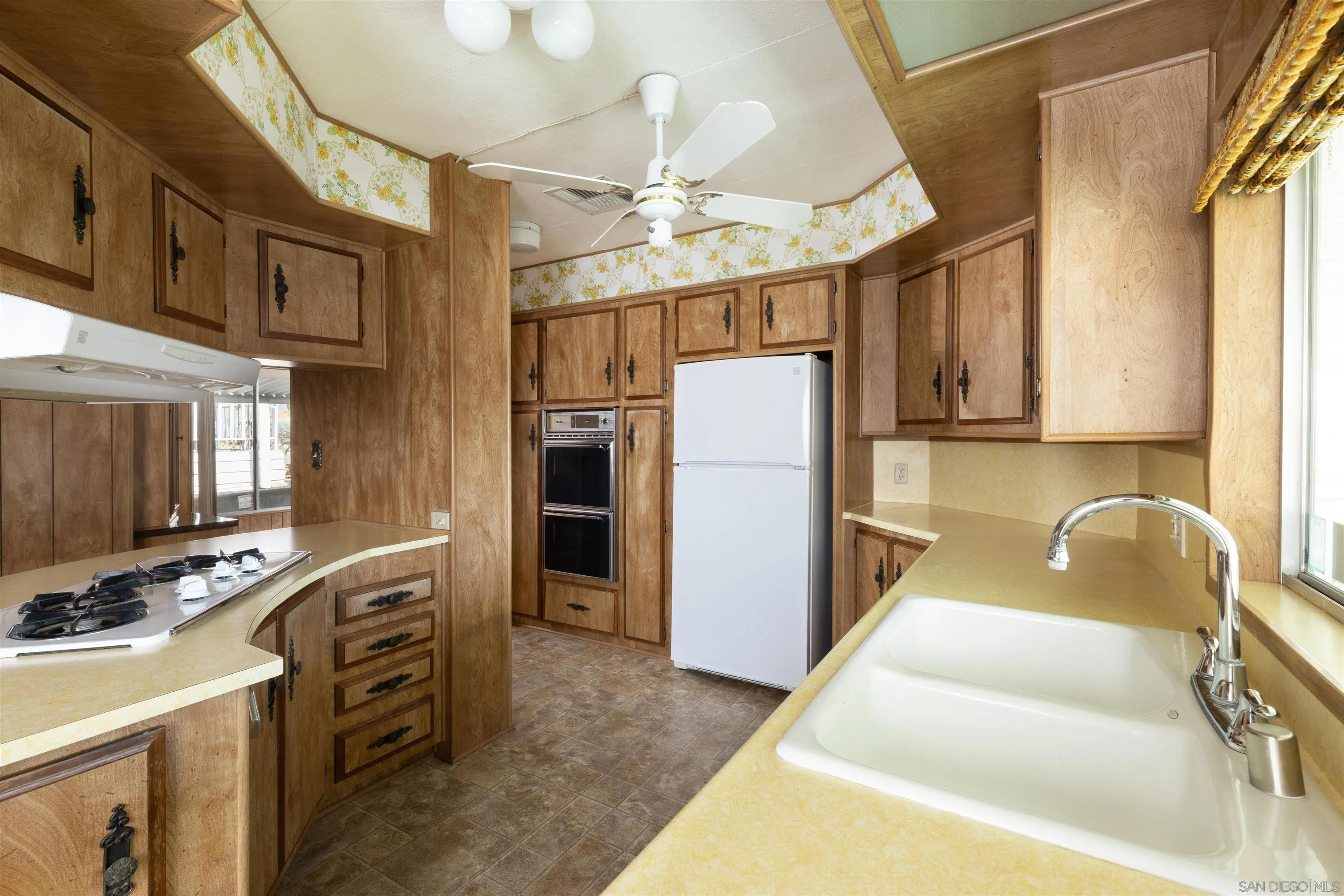 275 South Worthington Street, Unit 105 Spring Valley, CA 91977 - Photo 12 of 25 a kitchen with refrigerator a stove a sink cabinets and a dining table