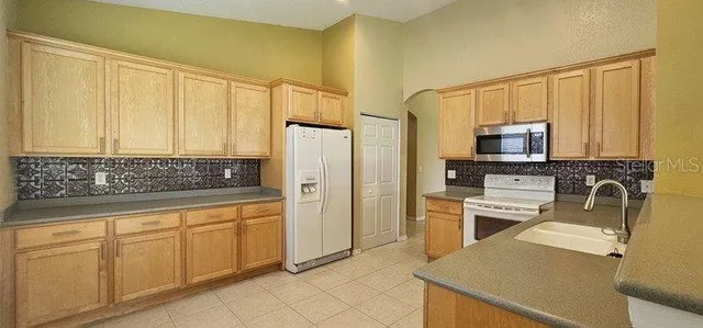 a kitchen with a refrigerator sink and cabinets