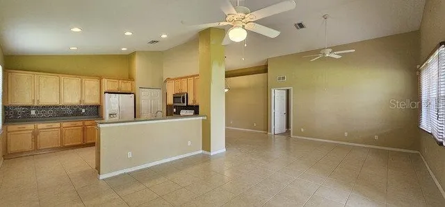 a large kitchen with stainless steel appliances a refrigerator and a stove top oven