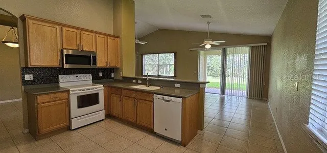 a kitchen with stainless steel appliances granite countertop a stove a sink and a microwave
