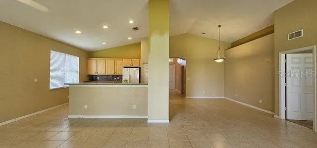 a view of a kitchen with a sink and a refrigerator