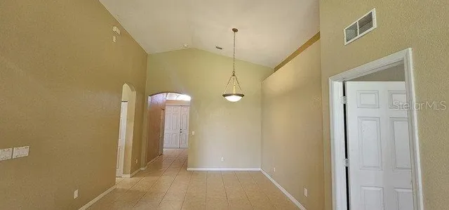 a view of a hallway with wooden floor and a bathroom