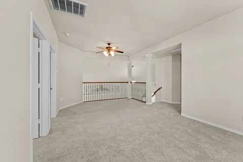 an empty room with windows and fan
