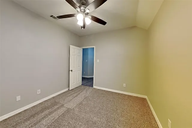 an empty room with a chandelier fan and a ceiling fan