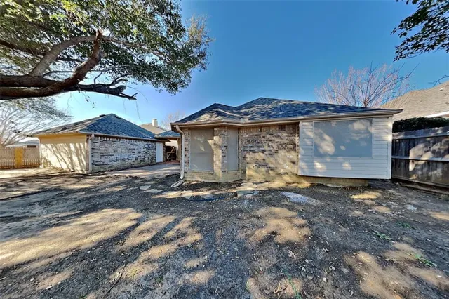 a view of a house with a yard and large tree