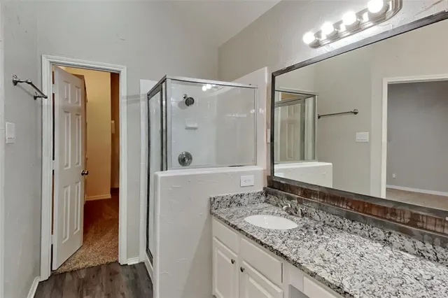 a bathroom with a granite countertop sink and a mirror