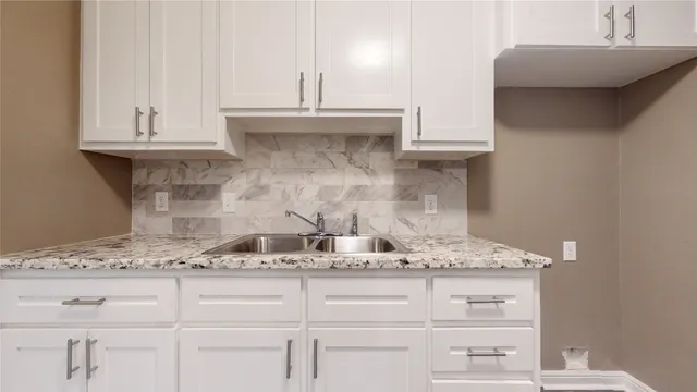 a kitchen with granite countertop white cabinets and a white stove