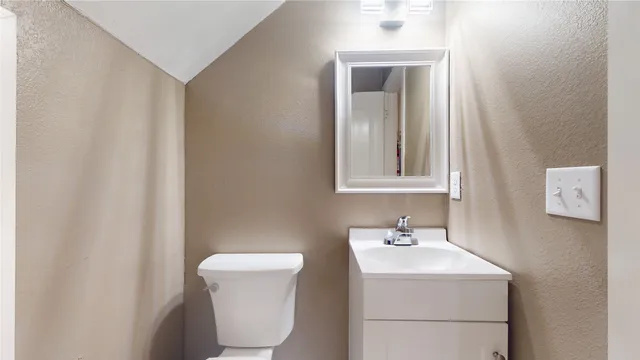 a bathroom with a sink toilet and mirror