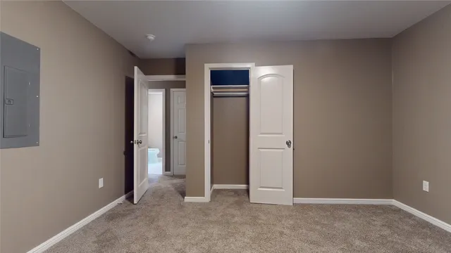 an empty room with closet and wooden door