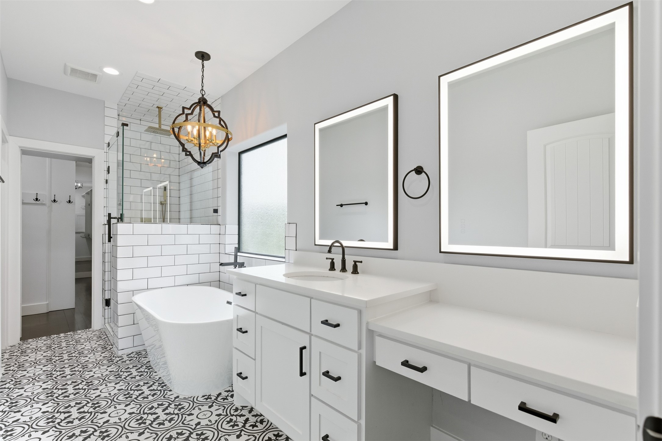 1018 Press Street Houston, TX 77020 - Photo 22 of 31 Beautifully designed primary bathroom with a spa-like soaking tub, stand-up shower, and seated vanity area. Includes smart mirrors with defog and lighting settings for added comfort.