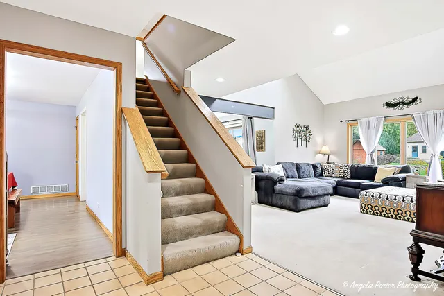 a living room with furniture and stairs