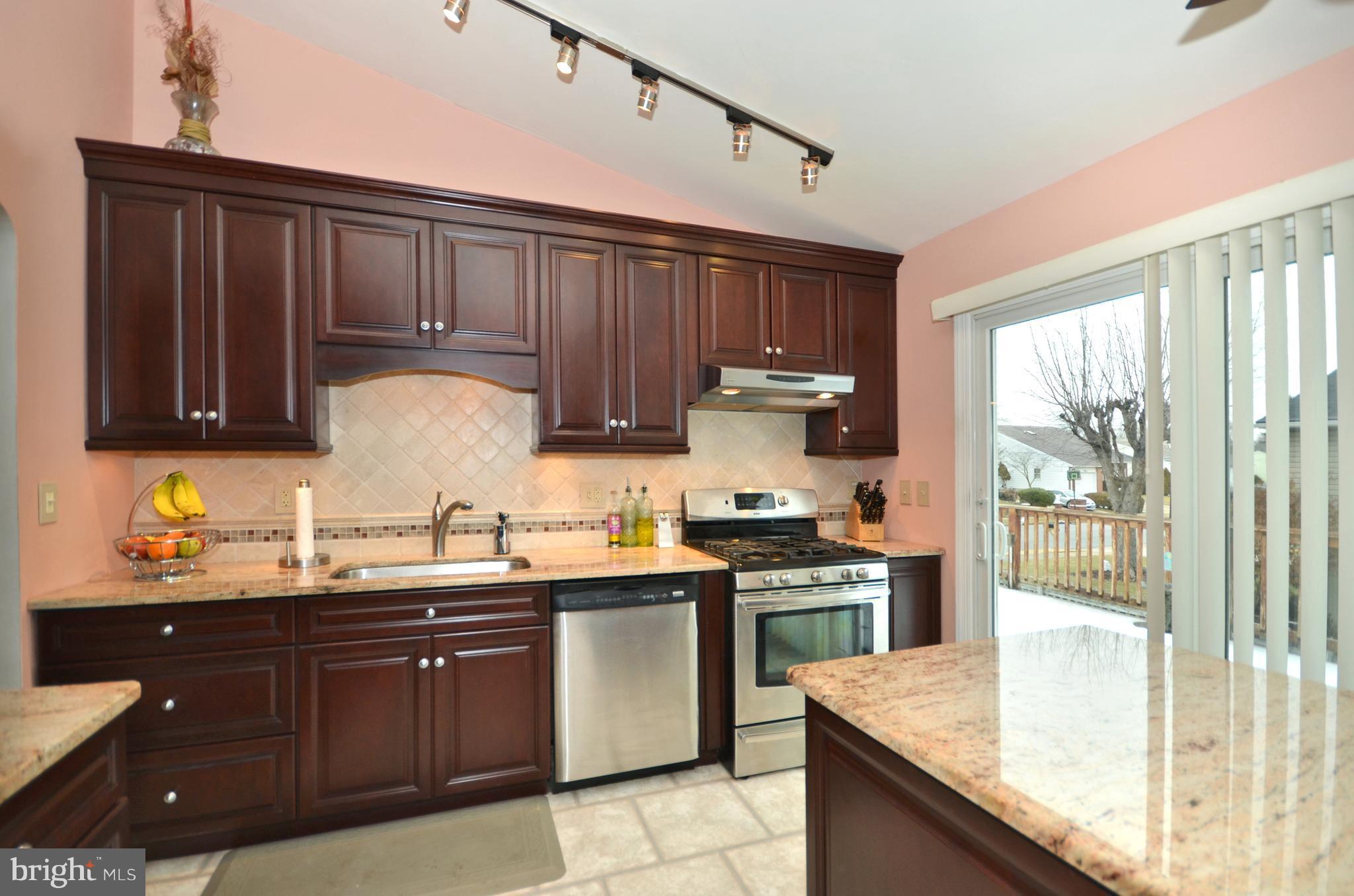 4806 Ebenezer Road Baltimore, MD 21236 - Photo 4 of 30 a kitchen with a sink a stove and wooden cabinets