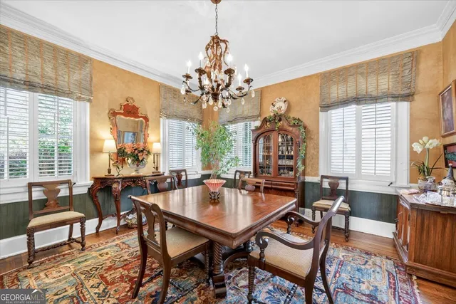 a dining room with wooden floor a chandelier a wooden table and chairs