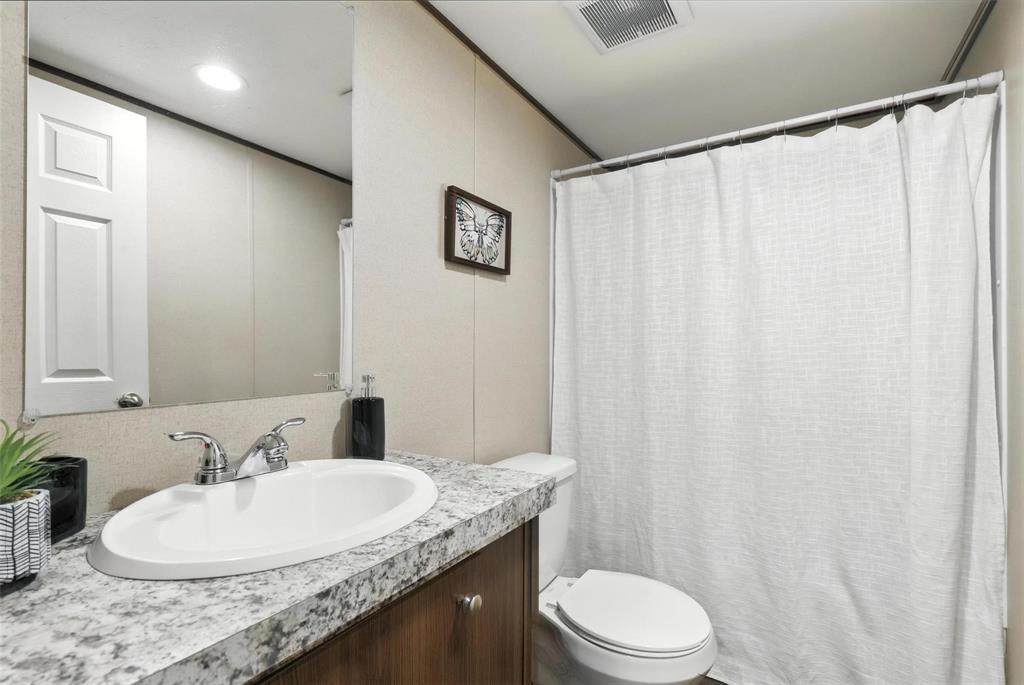 131 Kelly Court Azle, TX 76020 - Photo 17 of 22 a bathroom with a granite countertop sink and a mirror