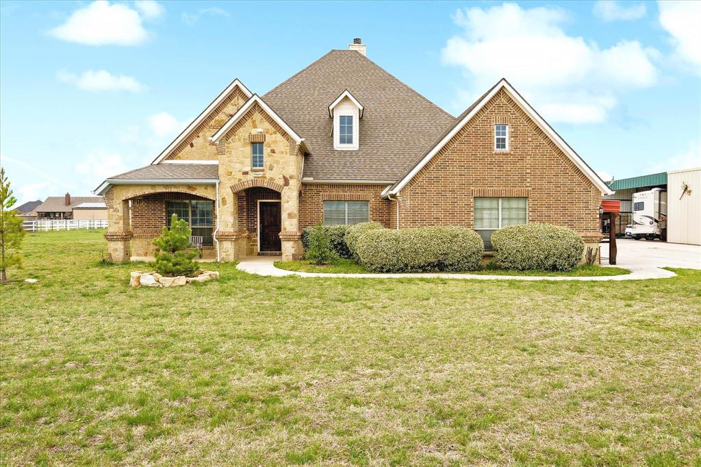 119 George Owens Road Ponder, TX 76259 - Photo 2 of 26 Brick and stone facade residence featuring a covered entryway, arched details, dormer windows, and a gabled roofline