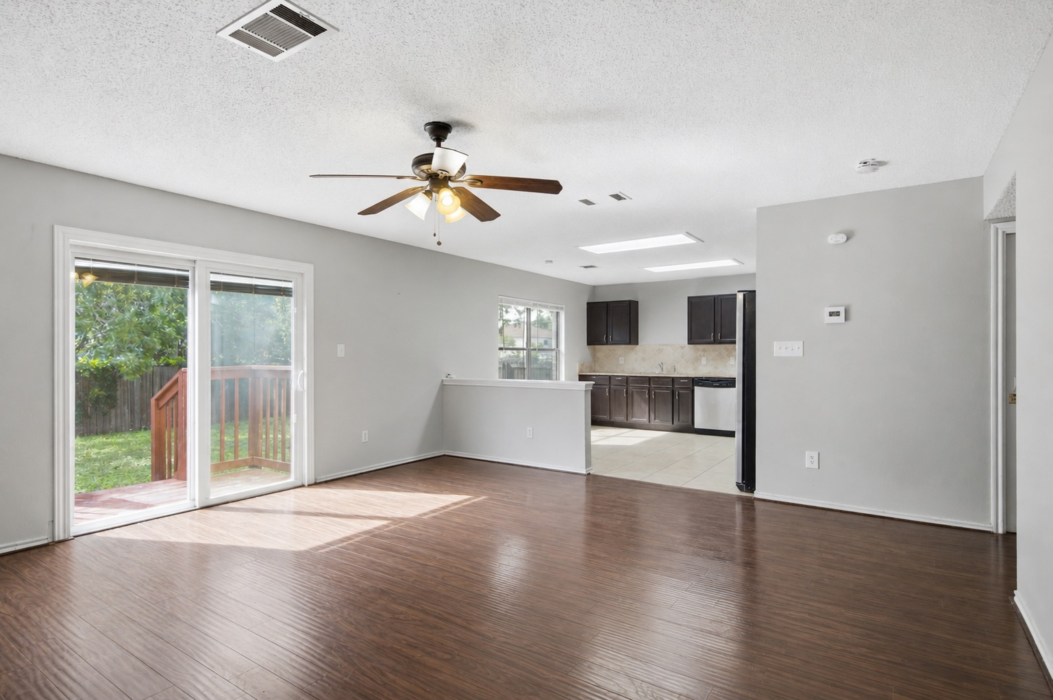 7900 Rosenberry Drive Austin, TX 78747 - Photo 6 of 27 Hardwood flooring extends throughout this generous living space, with sliding glass doors opening to the backyard.
