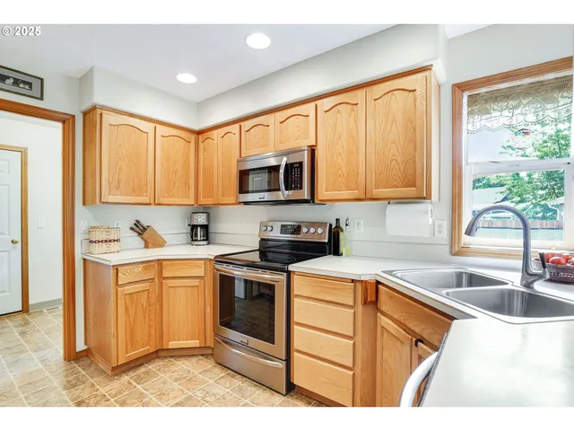 a kitchen with stainless steel appliances granite countertop a sink stove and microwave
