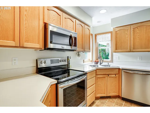 a kitchen with stainless steel appliances a stove sink microwave and cabinets
