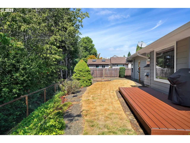 a patio with wooden floor a yard a table and chairs