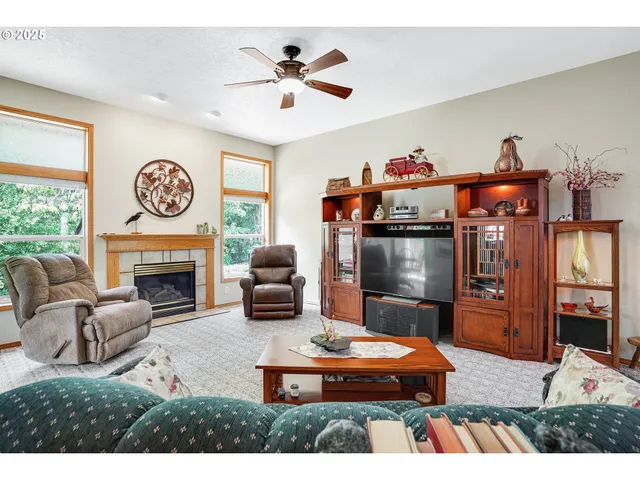 a living room with furniture a fireplace and a large window