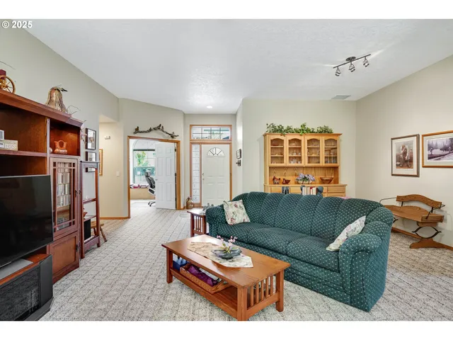 a living room with furniture a flat screen tv and a window