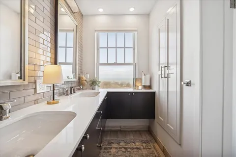 a bathroom with a double vanity sink toilet and shower
