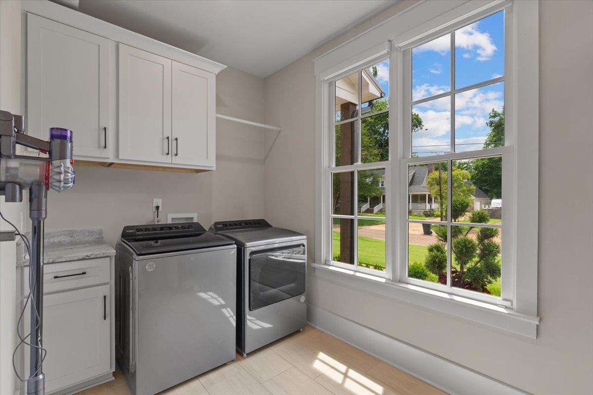 240 Burrows Road Collierville, TN 38017 - Photo 22 of 37 Laundry area featuring light wood-finish flooring, white cabinetry with dark hardware, a countertop with a speckled finish, a wall-mounted drying rack, and a double window with grid panes
