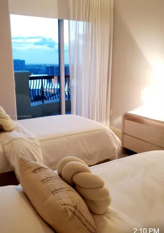 a bedroom with a bed and a lamp on the dresser